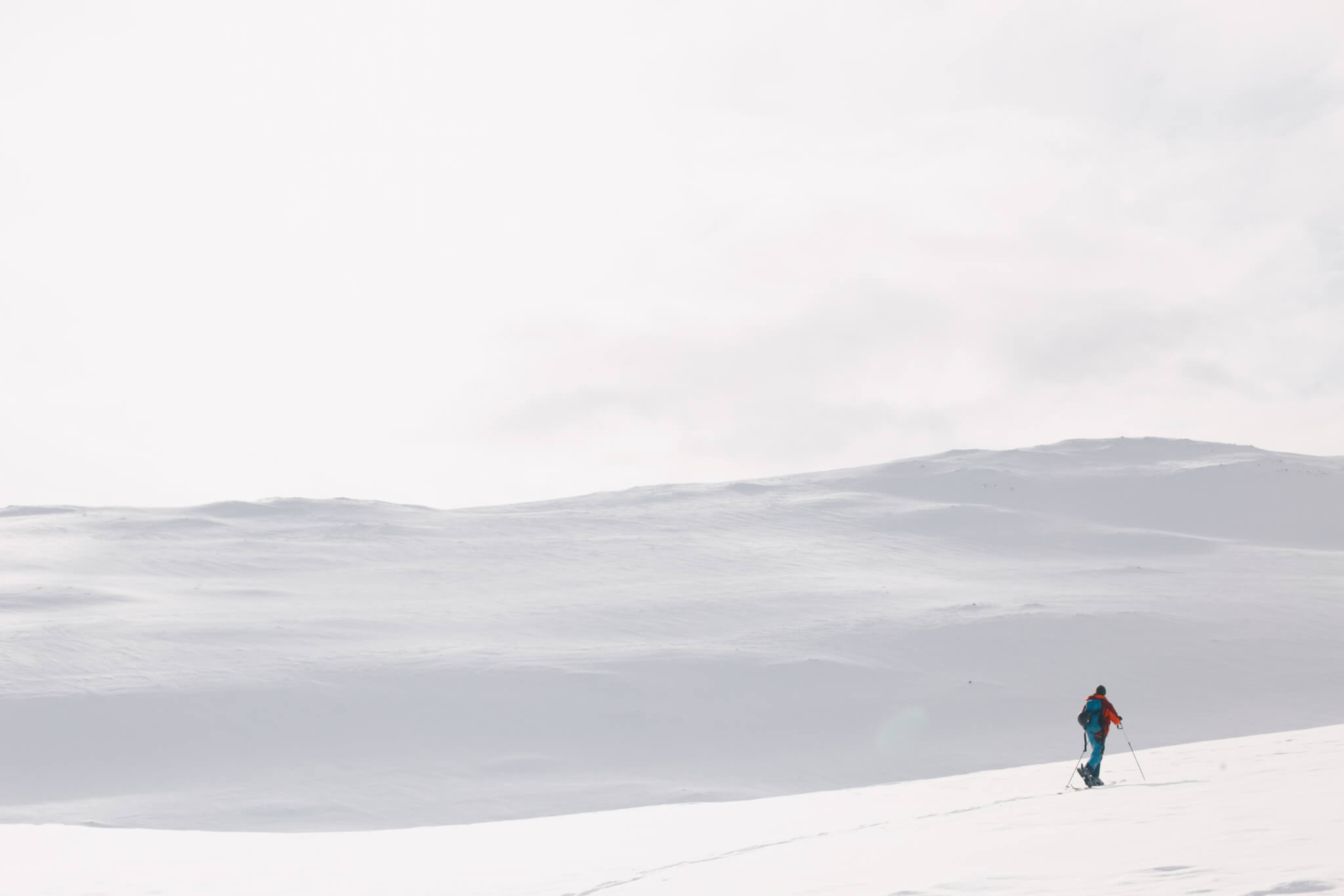 Skidåkare går på tur i snöigt fjällandskap.